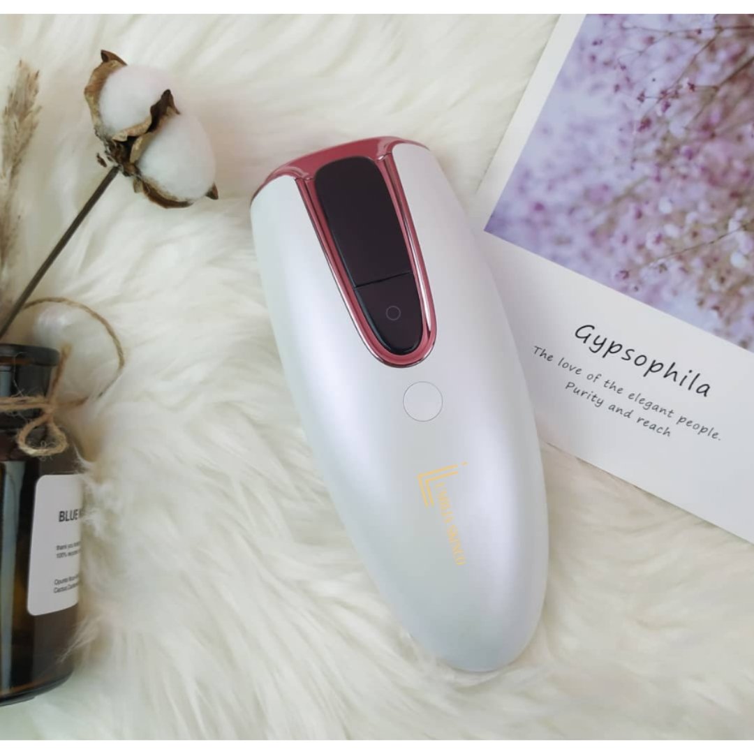 Lumilia Lux™ IPL Laser Hair Removal Device with rose trim on soft white fur, styled with dried florals and skincare flat lay – gentle, feminine skincare routine.